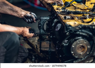 Qualified mechanic repairing hydraulic pumps, internal combustion engines, diesel engines in a car workshop. Testing engines on a dynamometer. Test stand. Oil change and engine overhaul. - Powered by Shutterstock