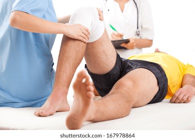 Qualified medical team examining knee condition in clinic for athletes.