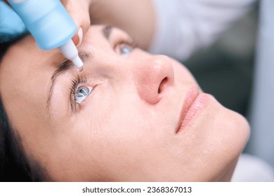 Qualified oculist preparing adult woman for retinal exam - Powered by Shutterstock