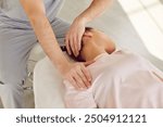 Qualified osteopath, chiropractor or manual therapist helping a young female patient stretch her tense muscles and relieve neck pain. Therapy, chiropractic, osteopathy concept