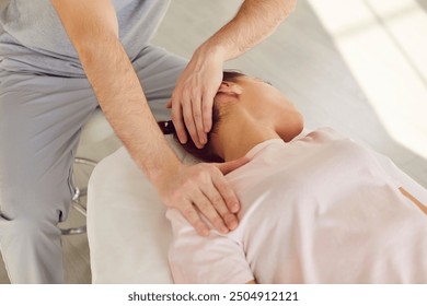 Qualified osteopath, chiropractor or manual therapist helping a young female patient stretch her tense muscles and relieve neck pain. Therapy, chiropractic, osteopathy concept - Powered by Shutterstock