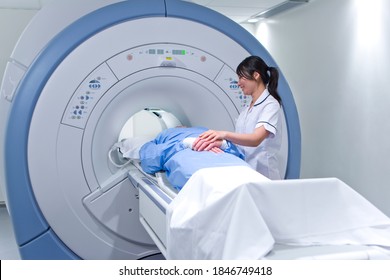 A Qualified Radiologist Smiling At The Patient While Helping Him During The MRI Scanning Test