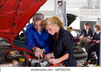 A Qualified Trainer Teaching His Student About The Parts Of An Automobile In A Vocational School Of Automotive Trade