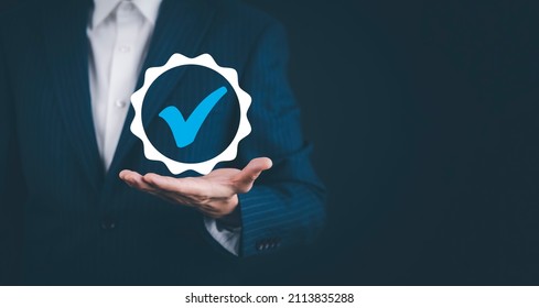 Quality assurance of business services, Businessman Hand shows the sign of the top service Quality assurance in Black background , Guarantee, Standards, ISO certification and standardization concept.