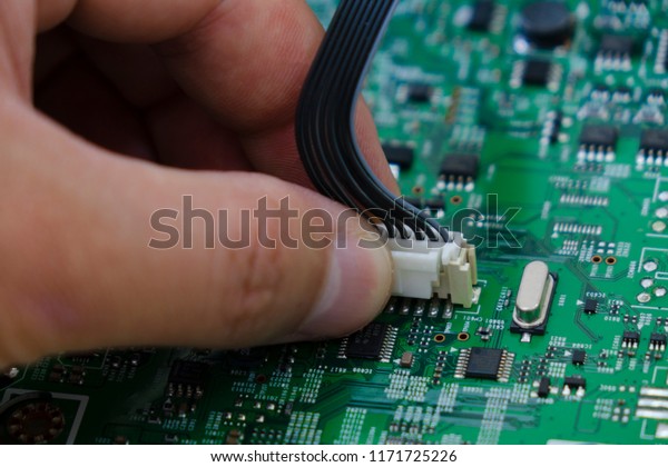 Quality\
control and assembly of SMT printed components on circuit board in\
QC lab of PCB manufacturing high-tech\
factory