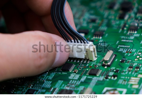 Quality\
control and assembly of SMT printed components on circuit board in\
QC lab of PCB manufacturing high-tech\
factory