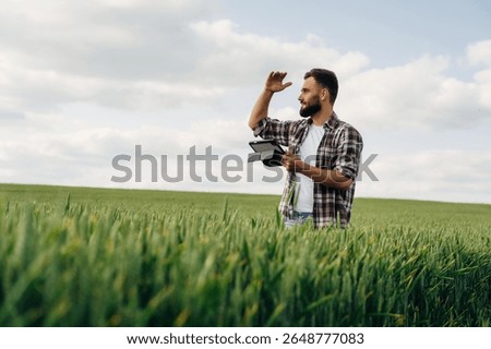 Quality control, with digital tablet. Man farmer is on the agricultural field.