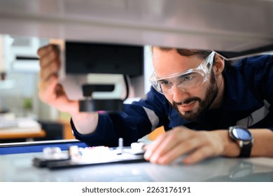 Quality control engineer specialist checking and inspecting circuit board at electronic factory