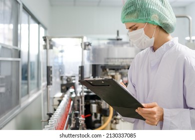 Quality Control Engineers Work In The Production And Bottling Facility For Fruit Juice Or Medicine. Staff Inspect The Quality Of Food And Drugs Before Delivery To Customers.