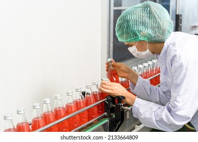 Quality Control Engineers Work In The Production And Bottling Facility For Fruit Juice Or Medicine. Staff Inspect The Quality Of Food And Drugs Before Delivery To Customers.