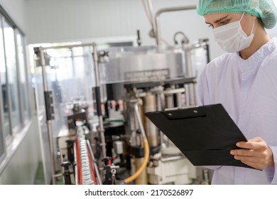 Quality Control Engineers Work In The Production And Bottling Facility For Fruit Juice Or Medicine. Staff Inspect The Quality Of Food And Drugs Before Delivery To Customers.