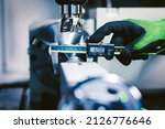 Quality control manufacturing.Hands of an engineer measures a metal part with a digital vernier caliper