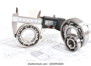 Quality control in modern mechanical engineering - caliper gauges, technical drawing and ball bearings on white background 