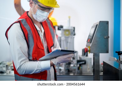 Quality control (QC) engineer monitoring and checking machine system in manufacturing factory - Powered by Shutterstock