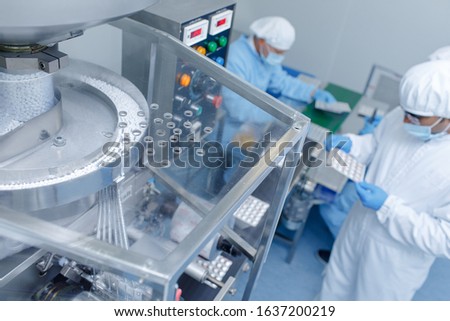 Quality Control Workers Examining Pills in Lab. Pharmaceutical lab technicians inspecting the quality of medical pills. Pharmaceutical Industry.
