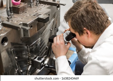 Quality Engineer Checks Deficiencies On The Injection Mold By A Microscope, Industrial Concept