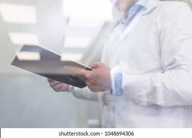 Quality Inspector Wearing White Medical Gown Inspecting A Laboratory. Quality Assurance Concept