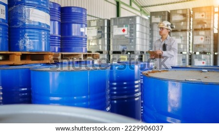 Quality inspectors are standing, check and record the quality and quantity of barrels chemical storage in the chemical factory. Quality control in production. Oil and chemical industrial concept