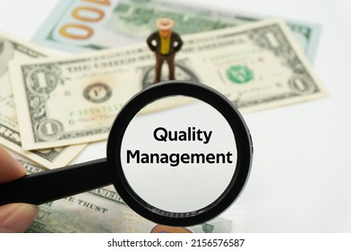 Quality Management.Magnifying glass showing the words.Background of banknotes and coins.basic concepts of finance.Business theme.Financial terms. - Shutterstock ID 2156576587