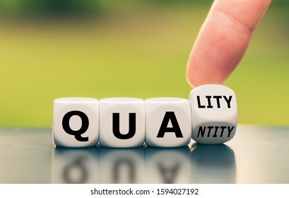 Quality over quantity. Hand turns a dice and changes the word "quantity" to "quality". - Shutterstock ID 1594027192
