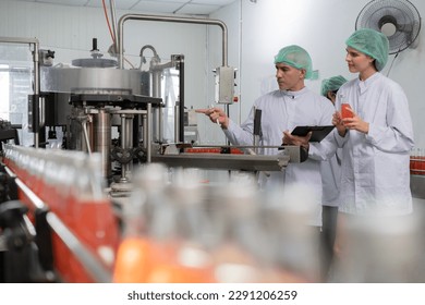 A quality supervisor or food or beverages technician discuss about process control of food and drugs before send product to the customer. Production leader recheck ingredient and productivity. - Powered by Shutterstock