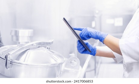 Quality supervisor on modern production food factory. Worker inspector using tablet for checking tank, banner of industry. - Powered by Shutterstock