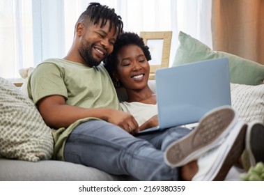 Quality Time Together. Shot Of A Young Couple Using A Laptop While Sitting On The Couch At Home.