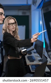 A quantum computing scientist explains a complex algorithm to a colleague, pointing to the code that will run on a quantum processor to solve a problem previously thought impossible.