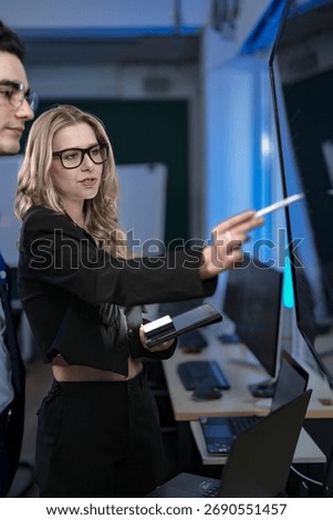 A quantum computing scientist explains a complex algorithm to a colleague, pointing to the code that will run on a quantum processor to solve a problem previously thought impossible.