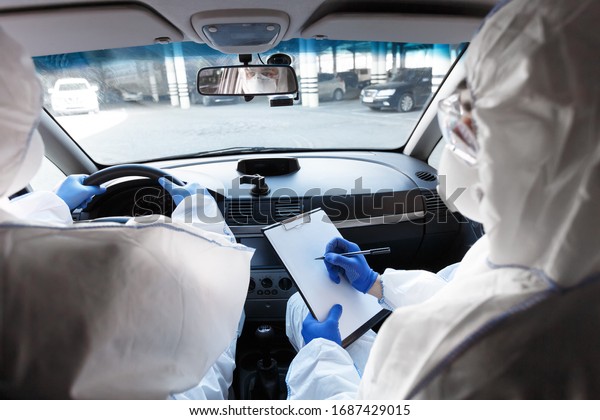 Quarantine.\
Virologists sitting in car and making plan of how to protect people\
from coronavirus, back view, copy\
space