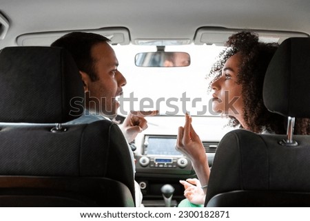 Quarrel In Car. Angry Middle Eastern Couple Having Conflict Expressing Disagree And Argument Sitting In Automobile Inside During Traffic Jam. Relationship Problems Concept. Rear View Shot