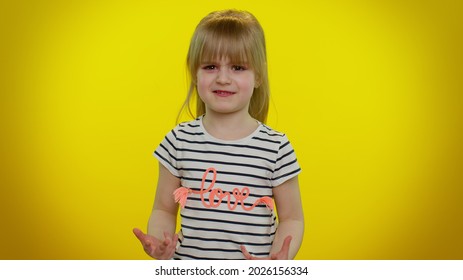 Quarrel. Displeased Blonde Child Girl 5-6 Years Old Gesturing Hands With Irritation And Displeasure, Blaming Scolding For Failure, Asking Why This Happened On Yellow Wall Background. Teen Kid Children