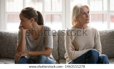 In quarrel elderly mother grown up daughter sit on couch separately having conflict, intergenerational misunderstanding, adult grandchild grandma difficult bad relations different generations concept Stock photo © 