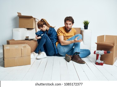   quarrel of a young couple, the family sits on the floor by the couch, moving to a new apartment                              - Shutterstock ID 1085172377