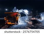 Quarry excavator works at night loading ore open pit mine, aerial top view.