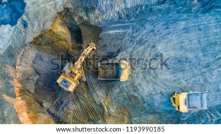 Quarry mining, work of the excavator and dump trucks, photo from the air