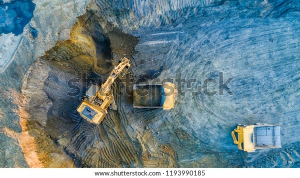 Quarry mining, work of the excavator and dump trucks,\
photo from the air