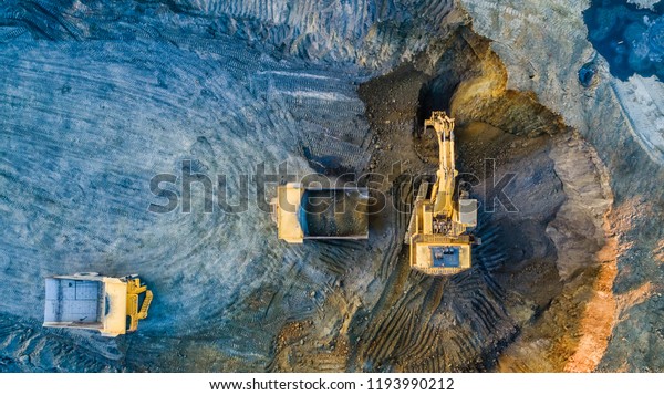 Quarry mining, work of the excavator and dump trucks,\
photo from the air