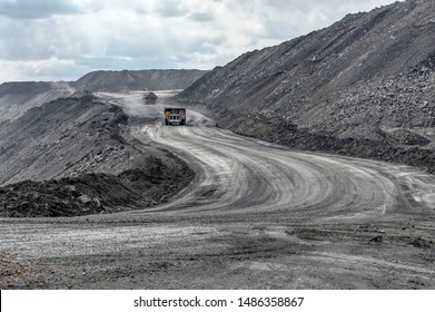 Quarry Truck Carries Coal Mined. A Mining Truck Is Driving Along A Mountain Road. Road For The Movement Of Heavy Trucks.