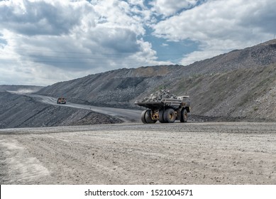 Quarry Truck Carries Coal Mined. A Mining Truck Is Driving Along A Mountain Road. Road For The Movement Of Heavy Trucks.