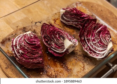 Quartered Radicchio In Glass Casserole Dish On Wooden Kitchen Table 