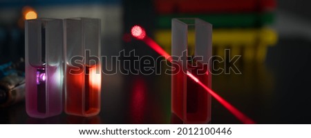 Quartz cuvette for laser chromatography with red liquid. Physical chemistry laboratory