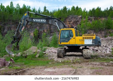 QUARTZITE, RUSSIA - JUNE 12, 2022: Volvo excavator in the raspberry quartzite quarry. Karelia