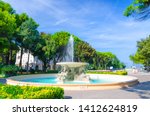 Quattro cavalli Four horses fountain with turquoise water in Parco Federico Fellini park with green trees in touristic city centre Rimini with blue sky background, Emilia-Romagna, Italy