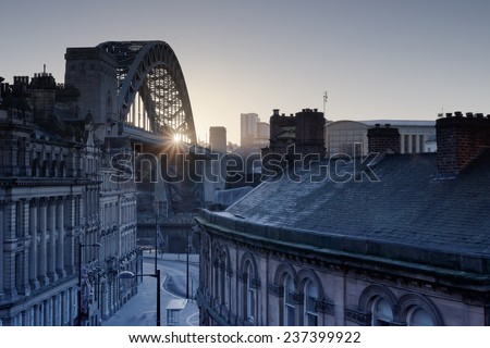 The Quayside at Newcastle upon Tyne and Gateshead photographed as the sun rises behind the Tyne bridge during the morning.