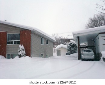 Quebec, Canada - 02-19-2022: The Driveway Leading To A Snowy House During A Snowstorm