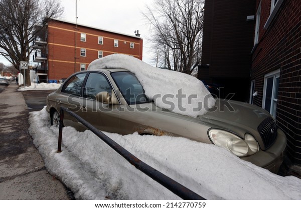 Quebec,\
Canada - 04-03-2022: A snowy car in a parking\
lot