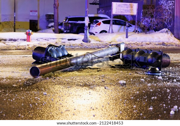 Quebec, Canada – February 11 2022: A broken traffic\
light and debris litter the street after a traffic accident on\
Boul. Charest Est.
