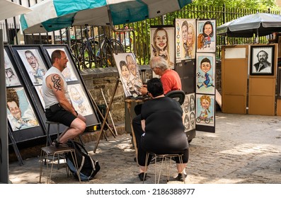 Quebec City, Canada - July 17, 2022: Street Artist Draws Caricature Of The Married Couple