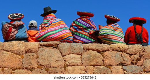 Quechua ladies and a young boy chatting on an ancient Inca wall.